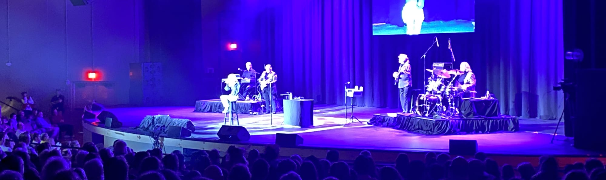 signer on stage in chair washed out by the lights Fresno